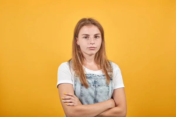 Mujer joven vistiendo camiseta blanca, sobre fondo naranja muestra emociones —  Fotos de Stock