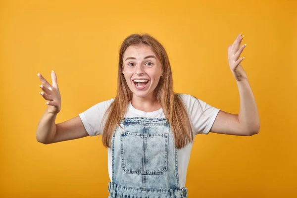 Mujer joven vistiendo camiseta blanca, sobre fondo naranja muestra emociones —  Fotos de Stock