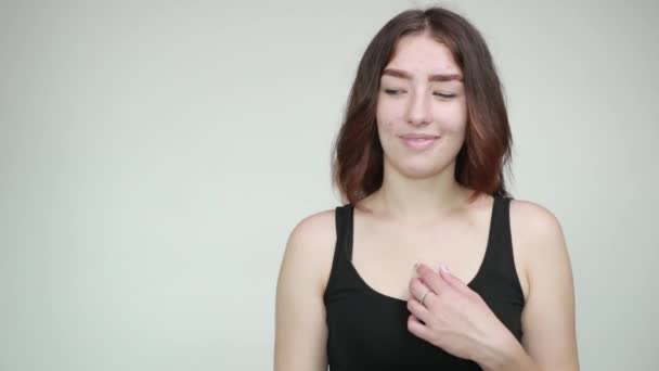 Όμορφο κορίτσι σε μαύρο αμάνικη μπλούζα πάνω από απομονωμένο λευκό φόντο δείχνει τα συναισθήματα — Αρχείο Βίντεο
