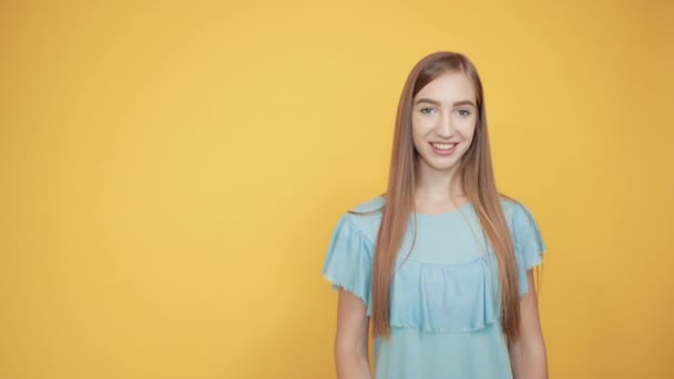 Брюнетка в голубой футболке на изолированном оранжевом фоне показывает эмоции — стоковое видео