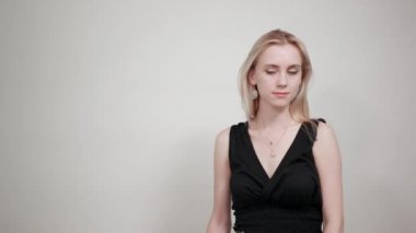 izole beyaz arka plan üzerinde siyah elbiseli sarışın kız duyguları gösterir