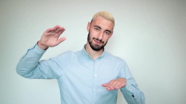 Hombre con cabello rubio, barba negra sobre fondo blanco aislado muestra emociones — Vídeo de stock