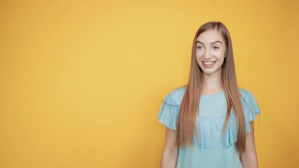 Lány barna kék póló több mint elszigetelt narancssárga háttér mutatja érzelmek — Stock videók