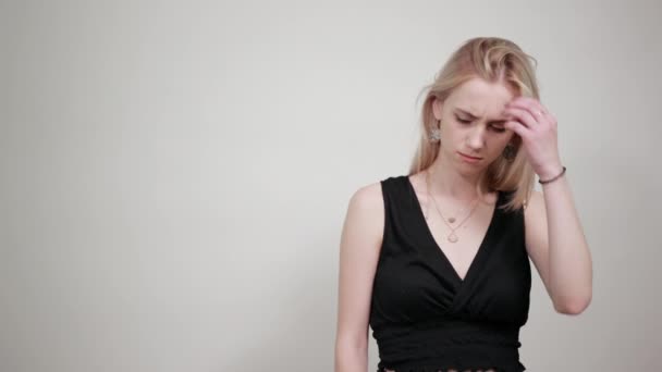 Блондинка в черном платье на изолированном белом фоне показывает эмоции — стоковое видео