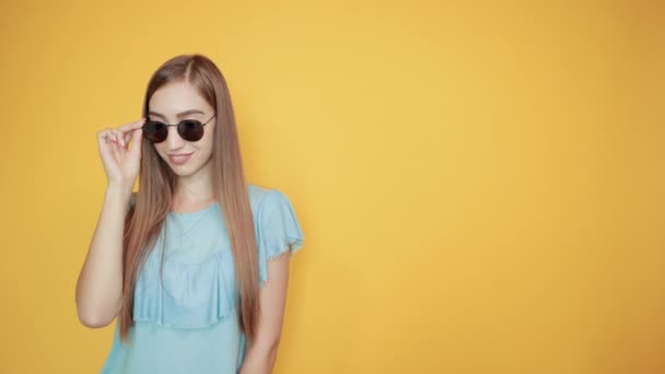 Chica morena en azul camiseta sobre fondo naranja aislado muestra emociones — Vídeo de stock