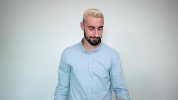 Homme aux cheveux blonds, barbe noire sur fond blanc isolé montre des émotions — Video