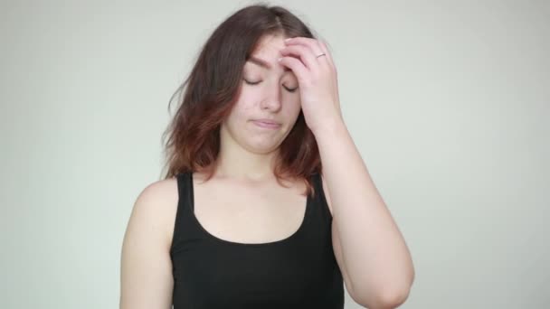 Beautiful girl in black tank top over isolated white background shows emotions — Stock Video