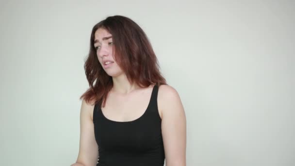 Belle fille en débardeur noir sur fond blanc isolé montre des émotions — Video