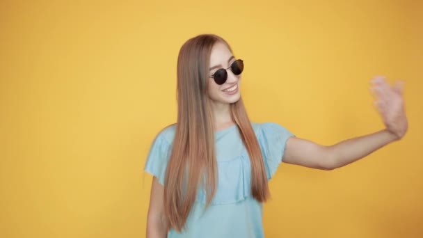 女孩布鲁内特在蓝色T恤在孤立的橙色背景显示情绪 — 图库视频影像