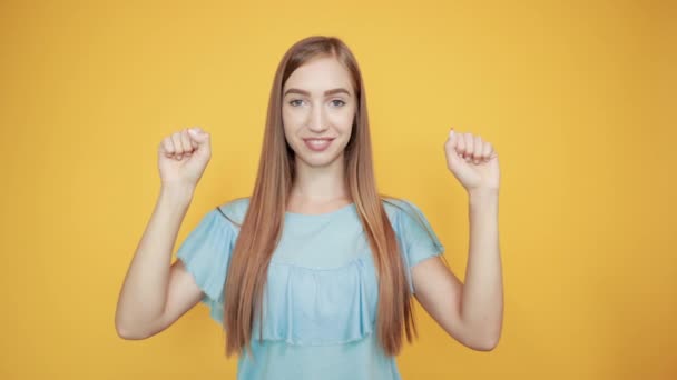 Meisje brunette in blauw t-shirt over geïsoleerde oranje achtergrond toont emoties — Stockvideo
