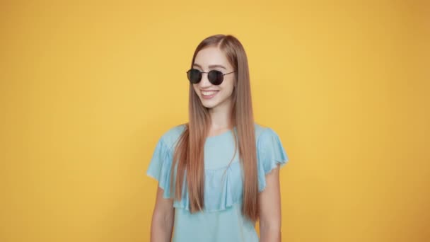 Dziewczyna Brunetka w niebieskim t-shirt na białym tle pomarańczowy pokazuje emocje — Wideo stockowe