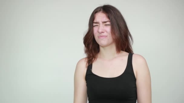 Beautiful girl in black tank top over isolated white background shows emotions — Stock Video