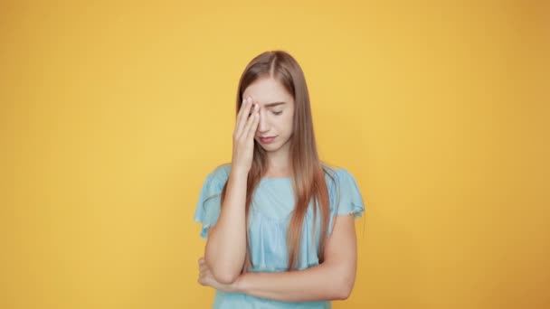 Chica morena en azul camiseta sobre fondo naranja aislado muestra emociones — Vídeos de Stock