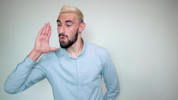 Homme aux cheveux blonds, barbe noire sur fond blanc isolé montre des émotions — Video