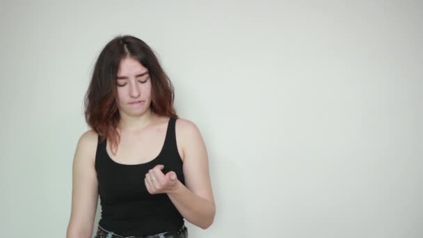 Mooi meisje in zwarte tank top over geïsoleerde witte achtergrond toont emoties — Stockvideo