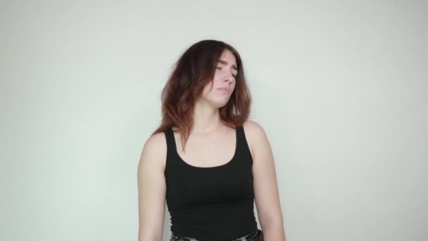 Bella ragazza in canotta nera su sfondo bianco isolato mostra emozioni — Video Stock
