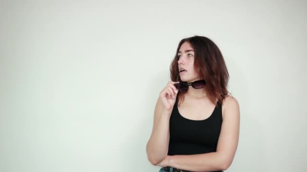 Vacker flicka i svart linne över isolerad vit bakgrund visar känslor — Stockvideo