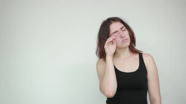 Beautiful girl in black tank top over isolated white background shows emotions — Stock Video