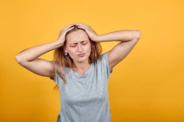 izole turuncu arka plan üzerinde gri t-shirt esmer kız duyguları gösterir