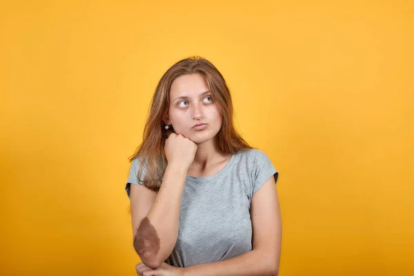 Brunette fille en gris t-shirt sur fond orange isolé montre des émotions — Photo