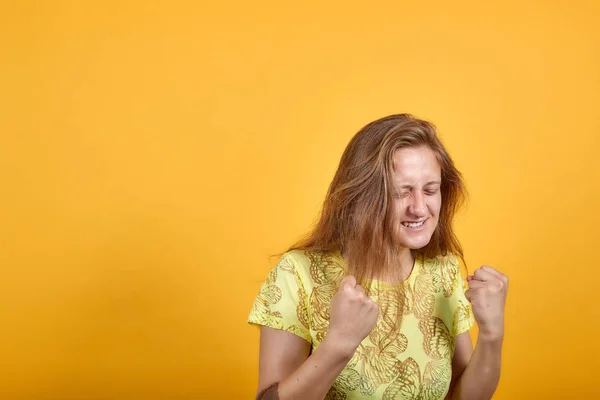Brunette flicka i gul t-shirt över isolerade orange bakgrund visar känslor — Stockfoto