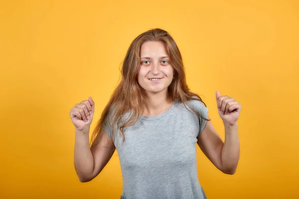 Morena chica en gris camiseta sobre aislado naranja fondo muestra emociones —  Fotos de Stock