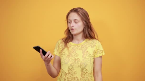 Brunetka dziewczyna w żółtym t-shirt na białym tle pomarańczowe pokazuje emocje — Wideo stockowe