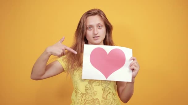 Brünettes Mädchen in gelbem T-Shirt über orangefarbenem Hintergrund zeigt Emotionen — Stockvideo