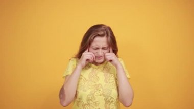 izole turuncu arka plan üzerinde sarı t-shirt esmer kız duyguları gösterir