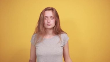izole turuncu arka plan üzerinde gri t-shirt esmer kız duyguları gösterir