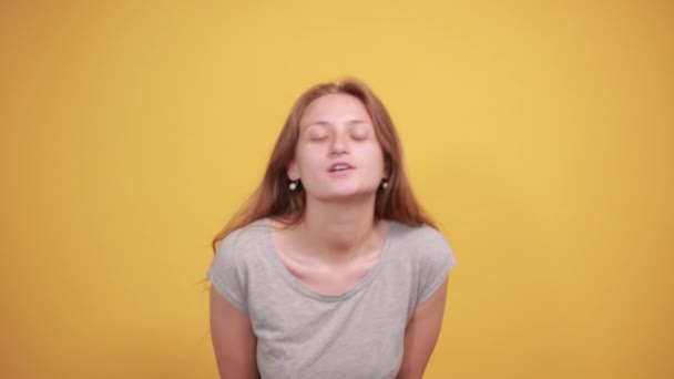 Morena chica en gris camiseta sobre aislado naranja fondo muestra emociones — Vídeos de Stock