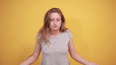 izole turuncu arka plan üzerinde gri t-shirt esmer kız duyguları gösterir