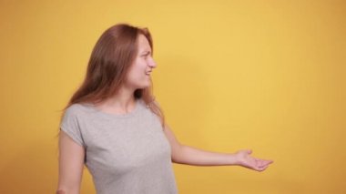 izole turuncu arka plan üzerinde gri t-shirt esmer kız duyguları gösterir