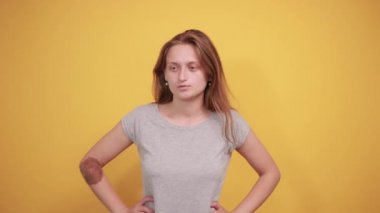 izole turuncu arka plan üzerinde gri t-shirt esmer kız duyguları gösterir