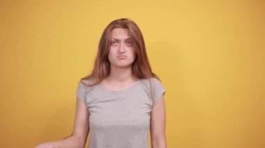 izole turuncu arka plan üzerinde gri t-shirt esmer kız duyguları gösterir