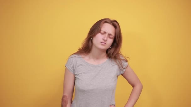 갈색 머리 소녀 에 회색 t-셔츠 위에 고립 된 오렌지 배경 쇼 감정 — 비디오