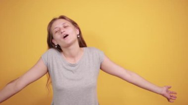 izole turuncu arka plan üzerinde gri t-shirt esmer kız duyguları gösterir