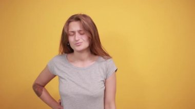 izole turuncu arka plan üzerinde gri t-shirt esmer kız duyguları gösterir