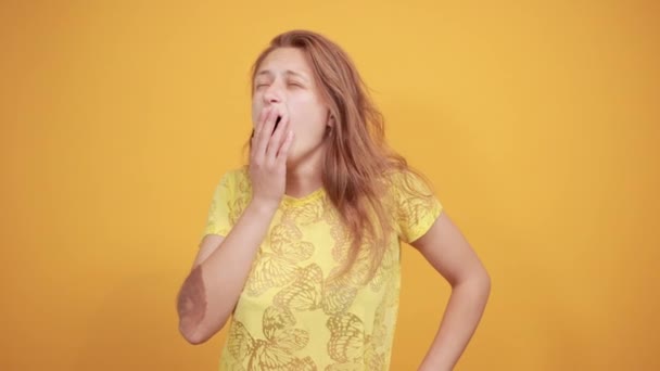 Chica morena en camiseta amarilla sobre fondo naranja aislado muestra emociones — Vídeos de Stock