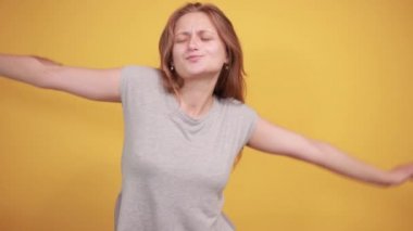 izole turuncu arka plan üzerinde gri t-shirt esmer kız duyguları gösterir
