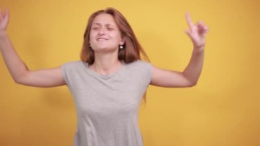 izole turuncu arka plan üzerinde gri t-shirt esmer kız duyguları gösterir