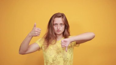 izole turuncu arka plan üzerinde sarı t-shirt esmer kız duyguları gösterir