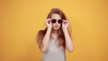 izole turuncu arka plan üzerinde gri t-shirt esmer kız duyguları gösterir