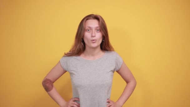 Izole turuncu arka plan üzerinde gri t-shirt esmer kız duyguları gösterir — Stok video