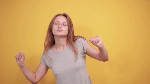 Brunette fille en gris t-shirt sur fond orange isolé montre des émotions — Video