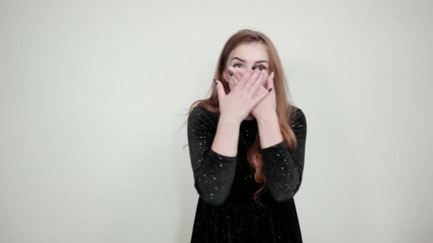 Chica de cabello castaño en vestido negro sobre fondo blanco aislado muestra emociones — Vídeos de Stock