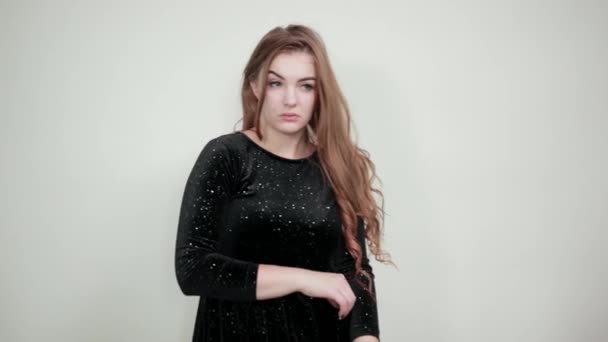 Meisje bruin haired in zwarte jurk over geïsoleerde witte achtergrond toont emoties — Stockvideo