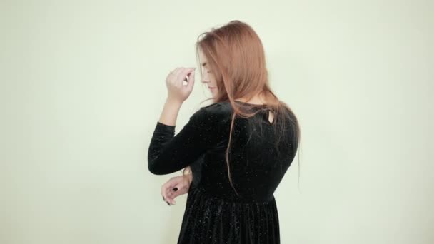Menina de cabelos castanhos em vestido preto sobre isolado fundo branco mostra emoções — Vídeo de Stock
