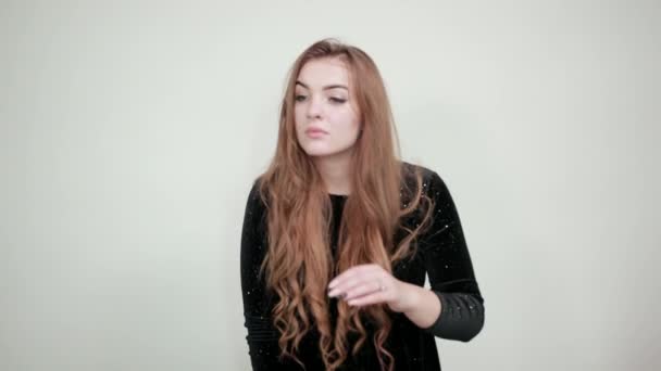 Girl brown haired in black dress over isolated white background shows emotions — Stock Video