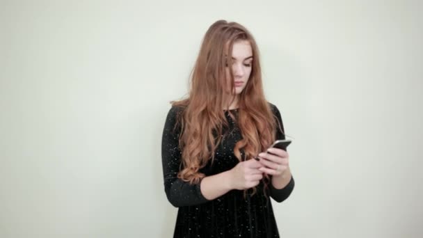 Lány barna hajú, fekete ruhában, mint egy elszigetelt fehér háttér mutatja érzelmek — Stock videók